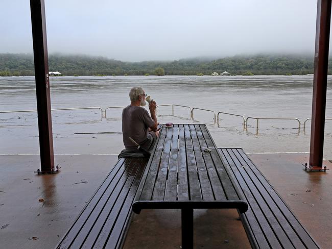 A man watches the level of the Clarence River come almost as high as the levee. Picture: Toby Zerna