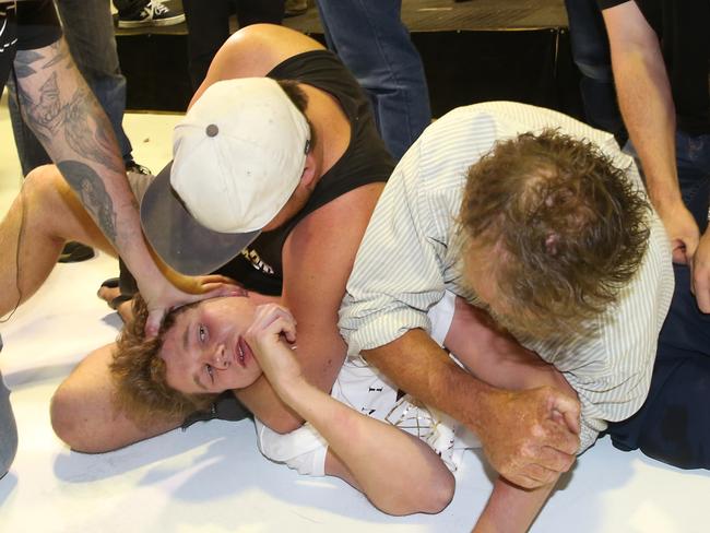 Supporters hold down Will Connolly after he smashed an egg over the head of Senator Fraser Anning. Picture: AAP