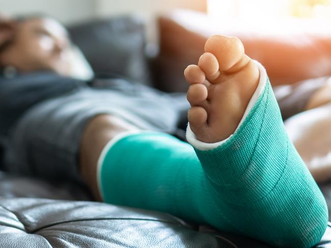 Bone fracture foot and leg on male patient with splint cast and crutches during surgery rehabilitation and orthopaedic recovery staying at home, injured worker istock