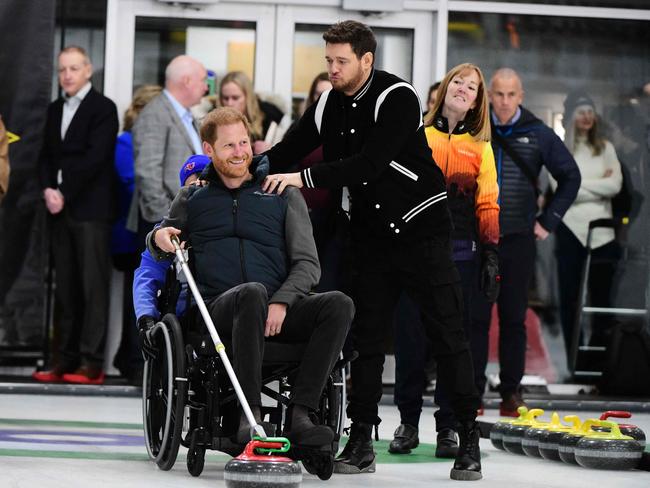 Michael Buble hams it up with Prince Harry at the wheelchair curling demonstration. Picture: AFP