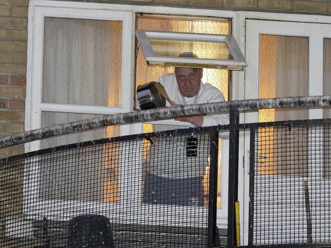 A man knocks a pot from his window near West Middlesex University Hospital to show his support for NHS staff. Picture: AP