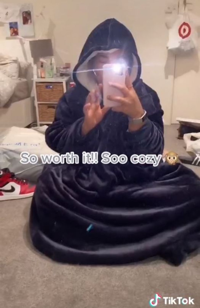 A Kmart shopper has found its $29 version of the expensive hooded blanket in navy blue. Picture: TikTok/@yaasssminee