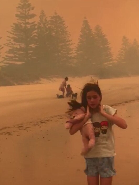 Displaced residents on the beach at Tathra as massive fires ravaged nearby homes.