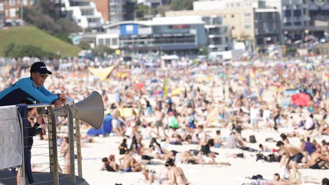 SYDNEY, AUSTRALIA - NewsWire Photos OCTOBER 05, 2020 - A lifeguard pictured watching the crowd at Bondi Beach on Monday October 05, 2020 as temperatures reached 30 degrees. Picture: NCA NewsWire / Christian Gilles