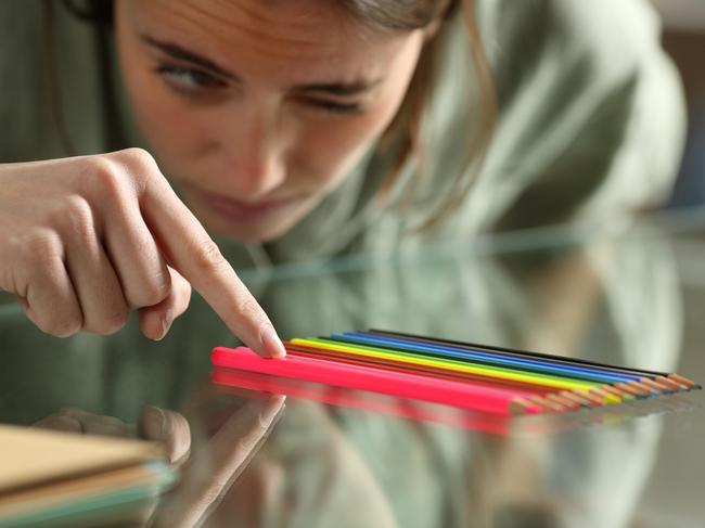 Obsessive compulsive woman aligning up pencils accurately on a glass table