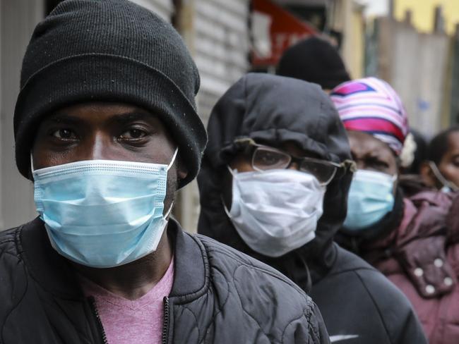 People wait for a distribution of masks and food in the Harlem neighbourhood of New York. Picture: AP