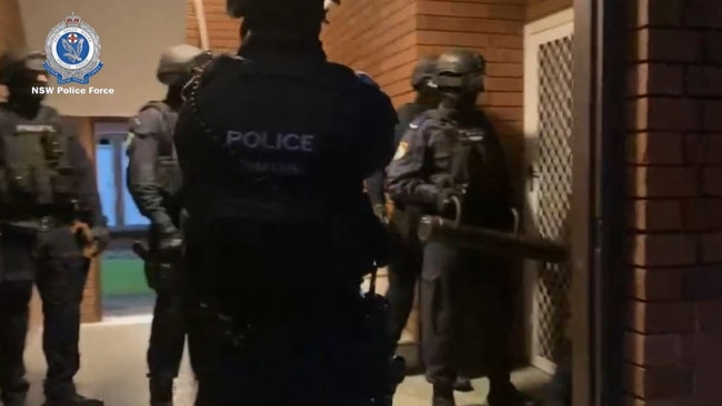 Police officers with a battering ram pictured at the arrest at Carramar on March 31. Picture: NSW Police