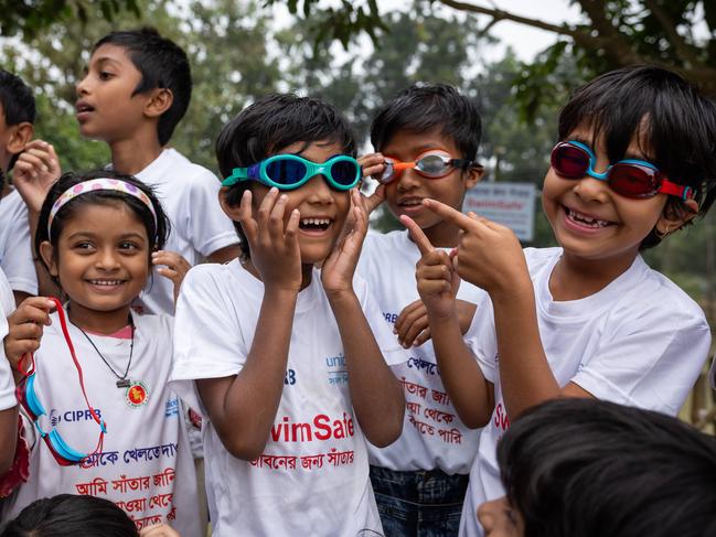 Takiya, 6 (center) receives her first goggles from Olympian Emma McKeon. Picture: Jason Edwards