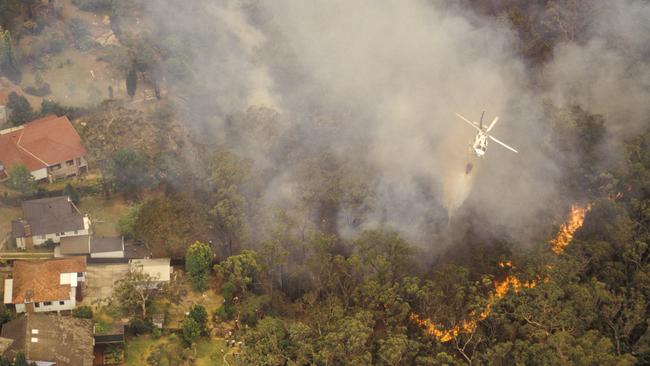 Aerial of water bombing a bushfire from a helicopter, Sydney Australia.