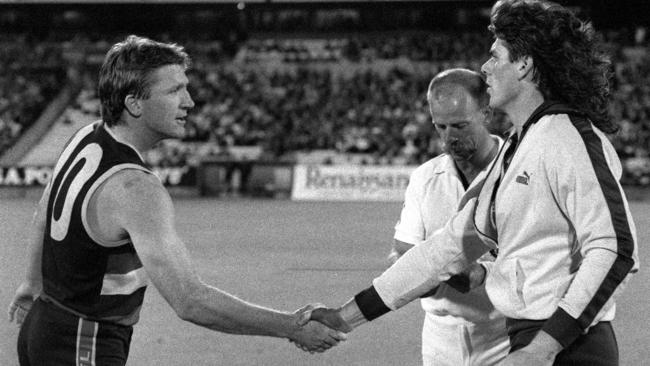 Inaugural Crows captain Chris McDermott shaking hands with Gary Ayres at the start of Crows’ first game in the AFL competition against Hawthorn at Football Park on March 22, 1991.