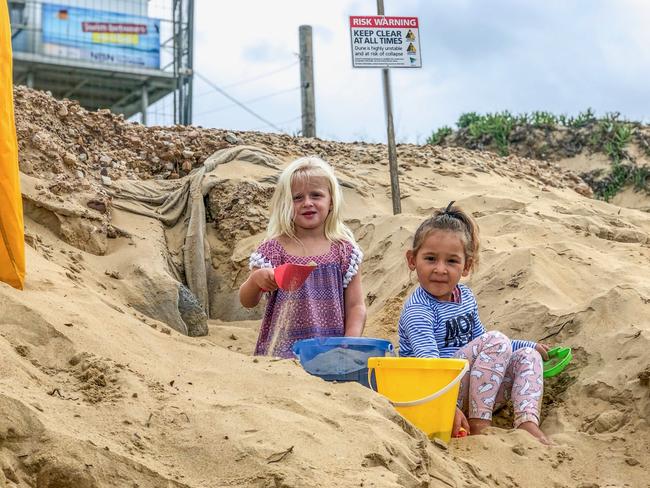 Lilly Summers (left) and Harriet Jones, both aged four, are forced to play amid risk warning signs and exposed rocks. Picture: supplied.