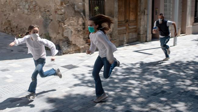 Joan chases his daughters Ines, 11, and Mar, 9, as they play in the street on Sunday in Barcelona after the end of a six-week lockdown. Picture: AFP