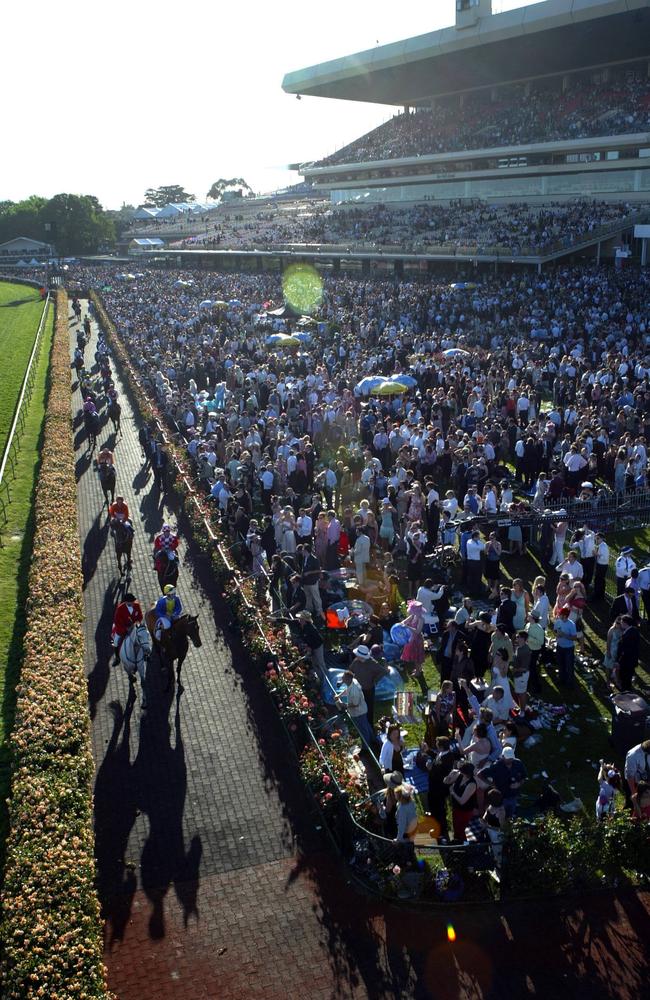 A huge crowd watches the field return to the mounting yard after the running of the last race at Flemington on Derby Day.