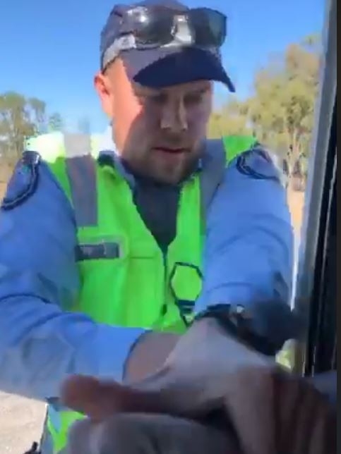 Yelarbon officer Vaughan Clacher attempts to remove driver Adam Thurrowgood from his truck, as shown in footage captured by Mr Thurrowgood.