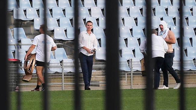 A Sharks player carries the trophy across Cronulla's stadium at 7.30am. Picture: Stephen Cooper