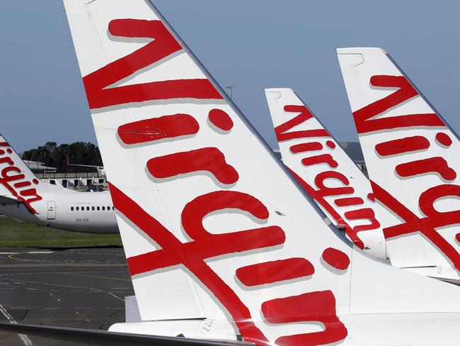 Virgin Australia planes are lined up at departure gates at Sydney Airport in Sydney, Wednesday, April 22, 2020. Virgin Australia is seeking bankruptcy protection, entering voluntary administration after a debt crisis worsened by the coronavirus shutdown pushed it into insolvency. (AP Photo/Rick Rycroft)