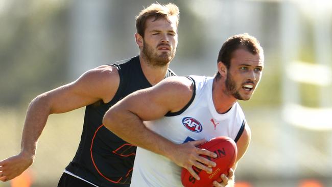 Kieren Briggs leads Matthew Flynn to the ball at GWS training.