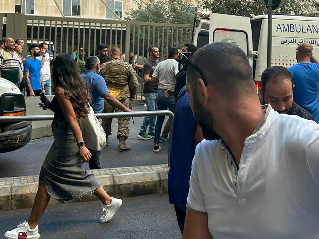 People react near an ambulance as the wounded are brought to a hospital in Beirut on September 17, 2024, after explosions hit locations in several Hezbollah strongholds around Lebanon amid ongoing cross-border tensions between Israel and Hezbollah fighters. Hundreds of people were wounded when Hezbollah members' paging devices exploded simultaneously across Lebanon on September 17, in what a source close to the militant movement said was an "Israeli breach" of its communications. (Photo by Anwar AMRO / AFP)