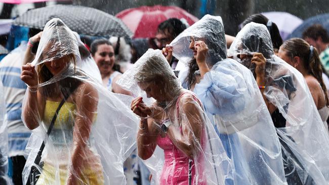 Fans shelter from the rain as they arrive for Swift's concert in Sydney on February 23, 2024.