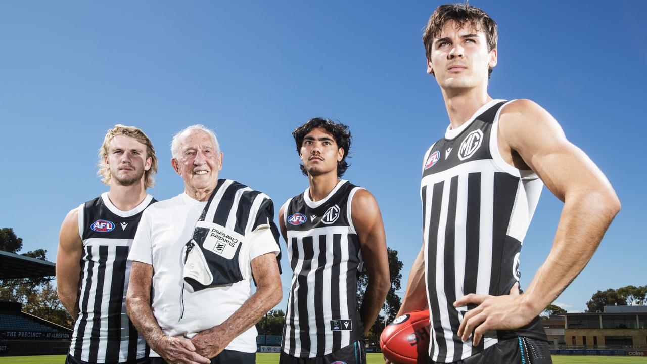 Port Legend John Cahill with Jason Horne-Francis, Jase Burgoyne and Connor Rozee in the prison-bar jumper. Picture: Simon Cross