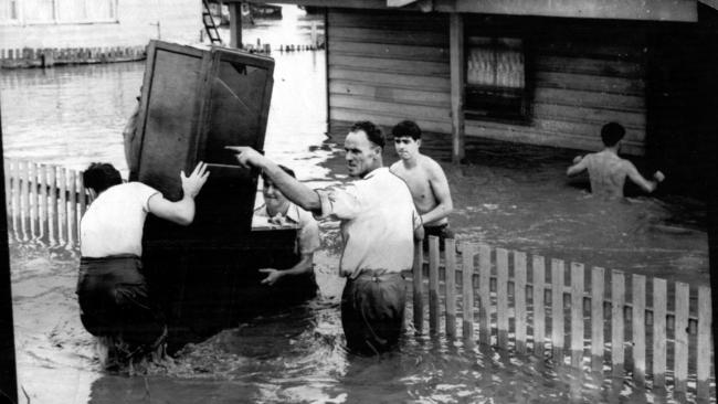 Furniture being removed from a house as the Iron Bark Creek breaks its banks during the Maitland floods in February 1955.