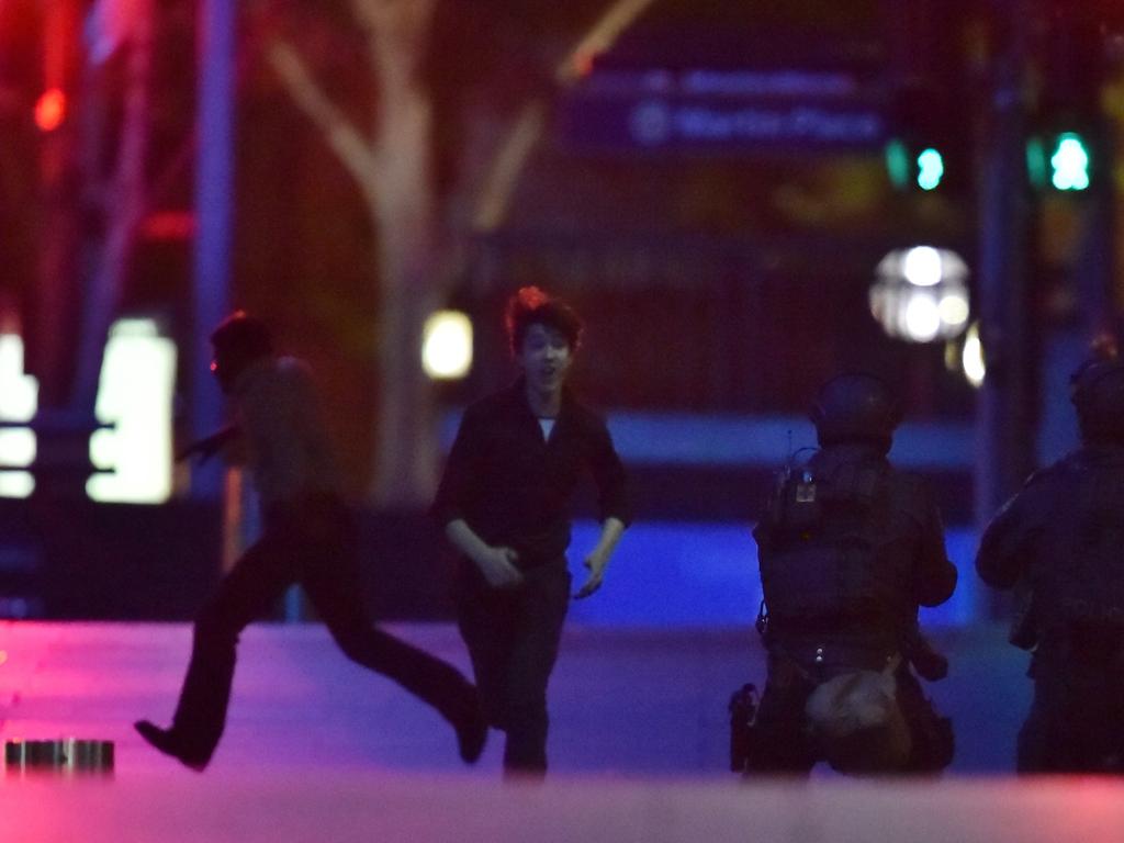 Hostages run out of a cafe in the central business district of Sydney. Picture: Peter Parks (AFP)