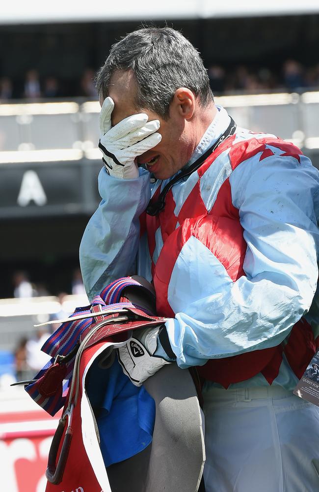 Red Cadeaux jockey Gerald Mosse in distress as he walks back to the mounting yard.