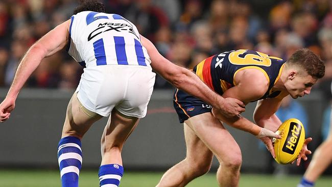 Adelaide’s Rory Laird gets past Todd Goldstein of the Kangaroos during the round 22 match at Adelaide Oval. Picture: Mark Brake/Getty Images