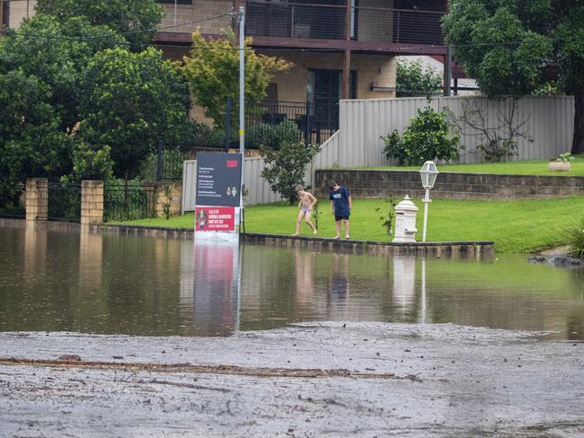 People look on as flood water spills onto the streets from The Hawkesbury River in Windsor. Picture: Getty