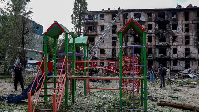 A policeman walks past a children's playground in front of a destroyed residential building following a Russian strike, in the city of Kryvyi Rig. Picture: AFP