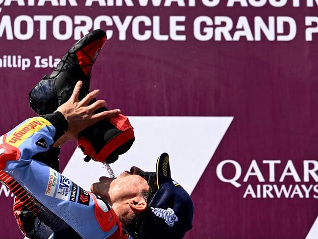 TOPSHOT - Gresini Racing MotoGP team rider Marc Marquez of Spain drinks from his boot after winning the MotoGP Australian Grand Prix on Phillip Island on October 20, 2024. (Photo by William WEST / AFP) / -- IMAGE RESTRICTED TO EDITORIAL USE - STRICTLY NO COMMERCIAL USE --