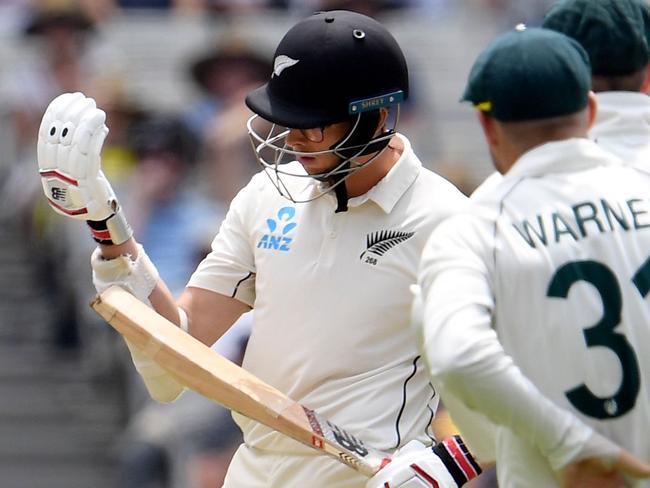 New Zealand batsman Mitchell Santner (3/R) inspects his armguard as the Australian players look on while awaiting a video review for a dismissal on the third day of the second cricket Test match at the MCG in Melbourne on December 28, 2019. (Photo by WILLIAM WEST / AFP) / -- IMAGE RESTRICTED TO EDITORIAL USE - STRICTLY NO COMMERCIAL USE --