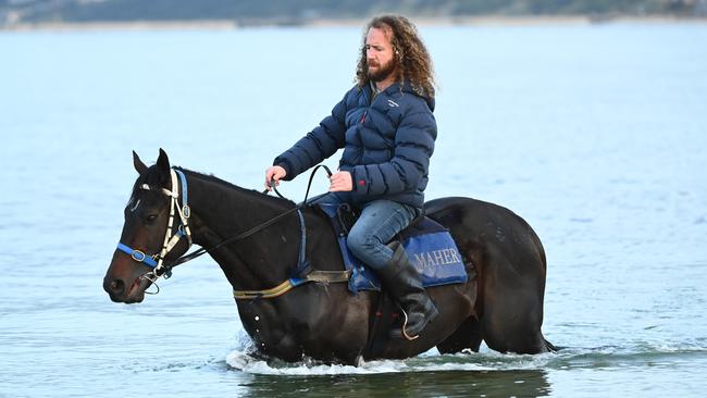 Trainer Ciaron Maher riding Sir Dragonet at the beach. Picture: Getty Images