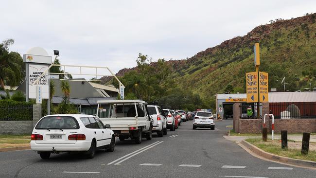 Police presence as cars line-up at the 3pm opening of the Gap View Hotel bottle shop in Alice Springs. Picture Mark Brake