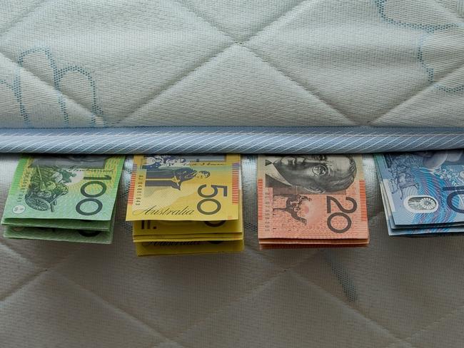 YOUR MONEY  hand cash money Australian currency dollars  under mattress bed Pic. John Donegan Pic. Donegan John