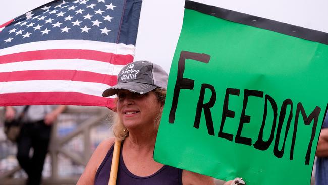 A protester holds a sign and a flag as she takes part in a rally against Covid-19 vaccine mandates in Santa Monica, California, on Sunday. Picture: AFP