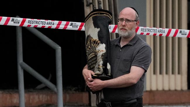 A member of the Jewish community recovers an item from the Adass Israel Synagogue in Melbourne.