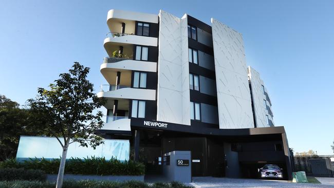 Police at the Hamilton apartment block where a badly decomposed body was found inside a metal box on a balcony. Picture: Tara Croser.