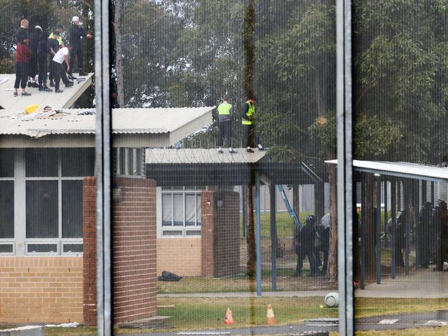 Inmates from the Frank Baxter Juvenile corrections centre Kariong taunt police from the roofs of various buildings . Some are armed with poles tennis rackets ect. Picture: John Grainger