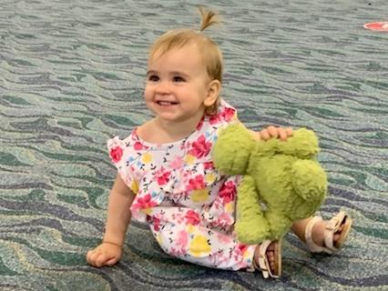 Mia Evans, 15 months, was reunited with Dino the green fluffy dinosaur at Townsville Airport after he was left on a Virgin Australia fight.