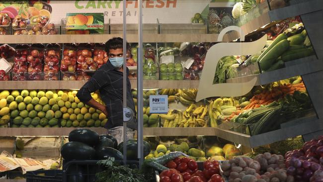 An Indian fruit vendor wearing a face mask as a precaution against the new coronavirus waits for customers in Bangalore, India. Picture: AP