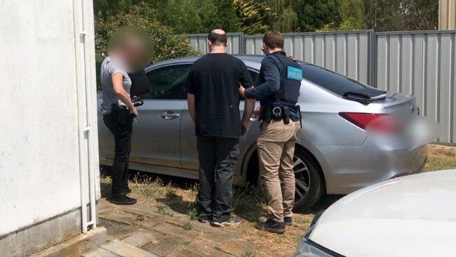 The first man in SA to be arrested for possessing a child-like sex doll is escorted to a waiting police car. Picture: AFP
