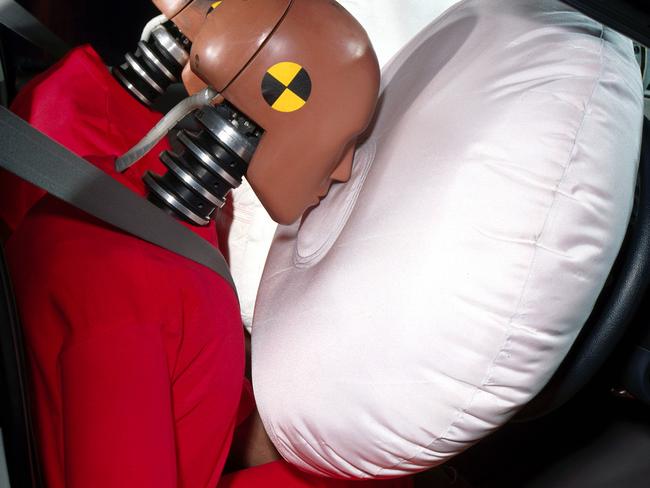 A Holden passenger airbag deploying simultaneously with driver's airbag in crash test dummy safety research experiment.