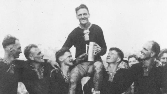 Jack Barnes being carried on teammates shoulders after victory, clutching the artillery shell trophy.