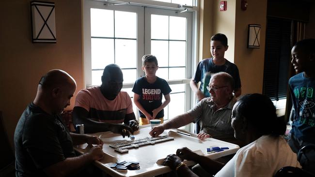 Hotel guests sit in a lobby playing dominos after the electricity was cut at a hotel as Hurricane Irma arrives into southwest Florida  in Fort Myers. Picture: AFP