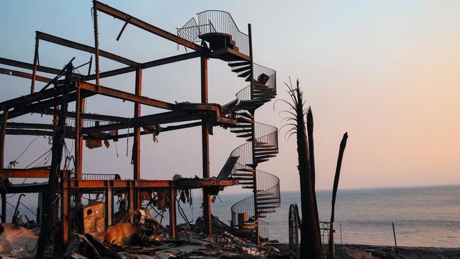 A spiral staircase remains standing amid the smouldering skeleton of a house destroyed by the Palisades fire at Malibu. Picture: AFP