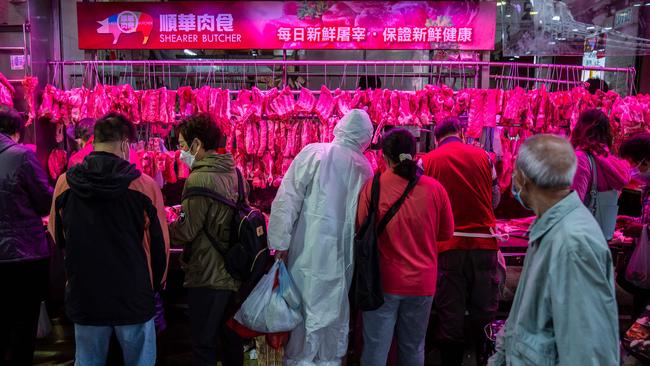 A man wearing personal protective equipment buys pork from a butcher in Hong Kong amid the city's worst-ever coronavirus outbreak. Picture: AFP.