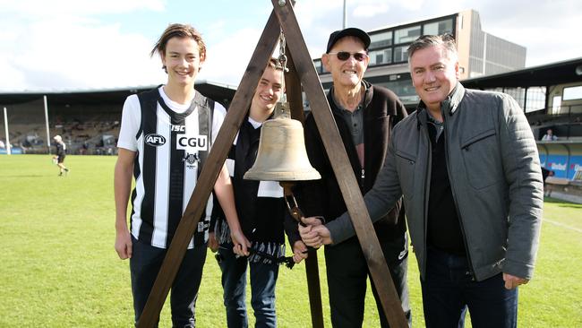 Collingwood president Eddie McGuire rings the bell to start a VFL games with his two sons and Collingwood great Ted Potter. Picture: Michael Klein