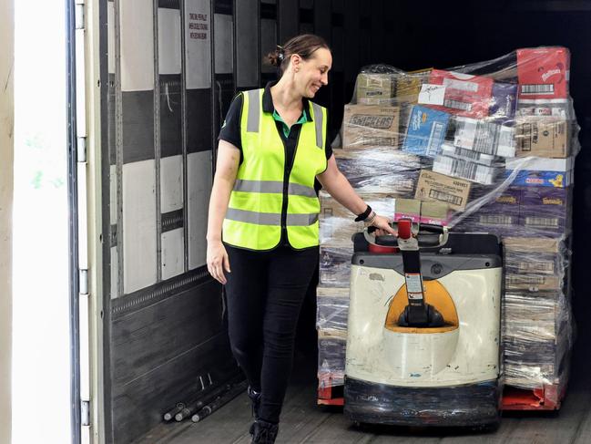 Woolworths has taken delivery of 448 pallets of groceries for their Far North Queensland stores, after flooding rains cut the road network and stopped deliveries. Woolworths Cairns Central assistant store manager Lauren Oxenham removes pallets of food off the truck on Thursday morning. Picture: Brendan Radke