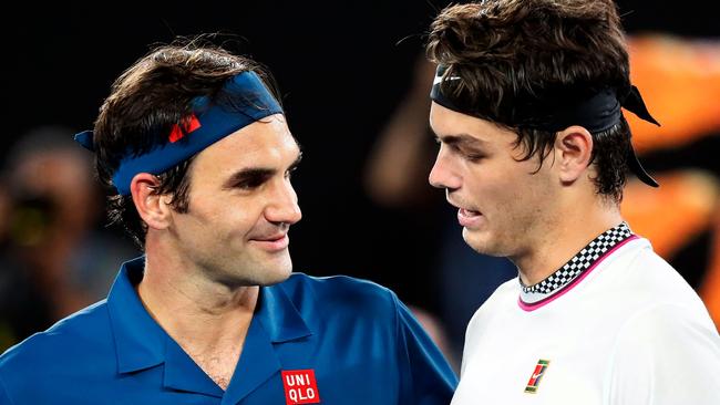 Switzerland's Roger Federer speaks with Taylor Fritz after winning their men's singles match.